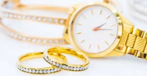 Luxury gold ring and lady gold watch on white