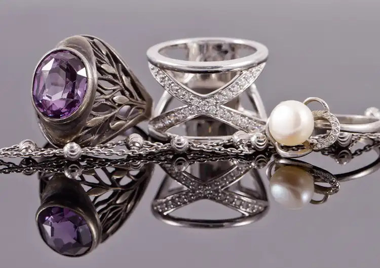 A pile of sterling silver cocktail rings and other silver jewelry