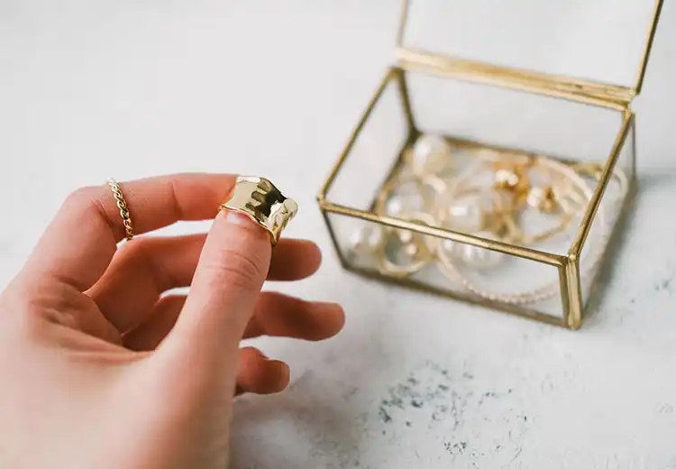 A clear jewelry box of gold jewelry