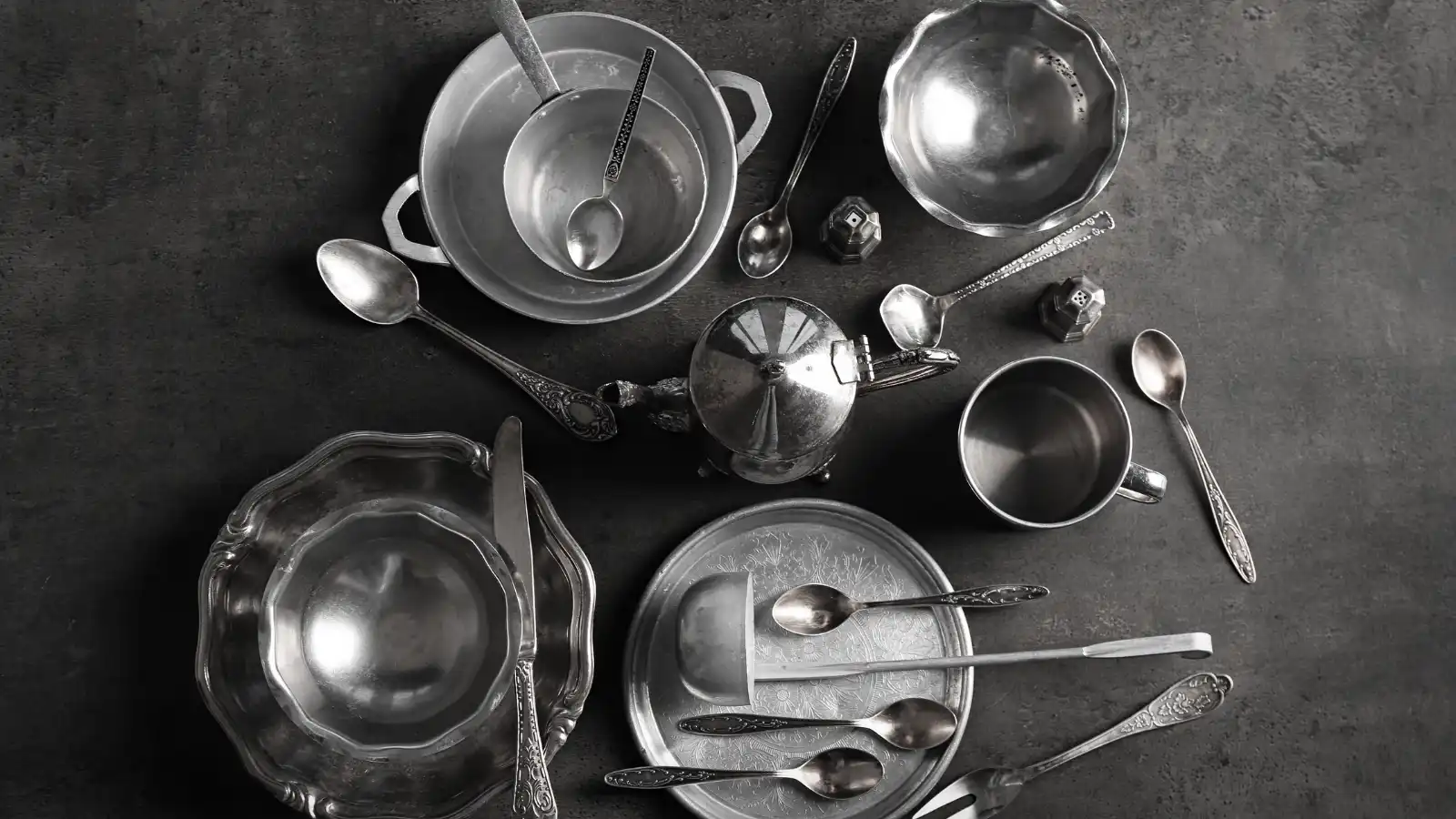 a pile of sterling silver or plated dishes.